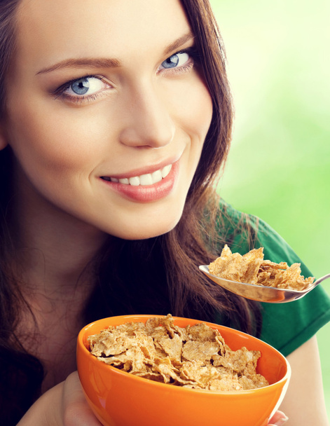mooie vrouw eten muesli of cornflakes - Foto, afbeelding