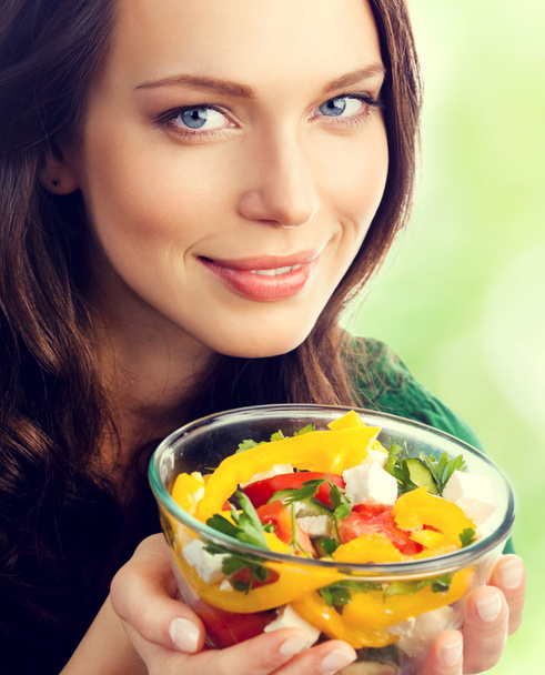Jonge mooie vrouw met plaat van salade - Foto, afbeelding