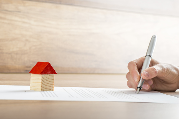 Closeup of new homeowner signing a contract of house sale or mor - 写真・画像
