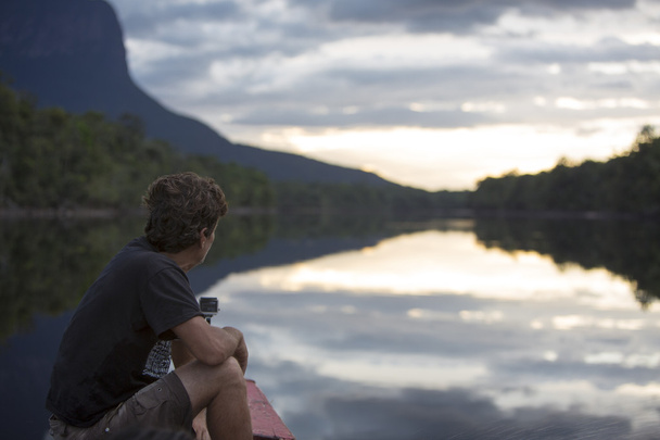 Man op zoek naar de zonsondergang op de Auyantepui-berg in het Canaima - Foto, afbeelding