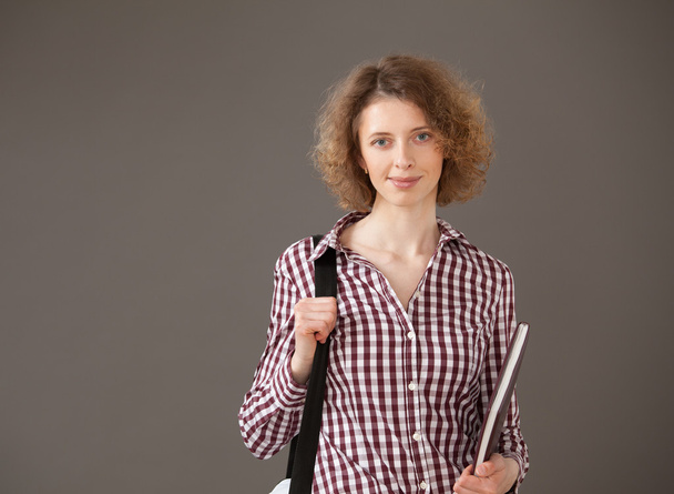 Woman holding a book and a bag - Foto, afbeelding
