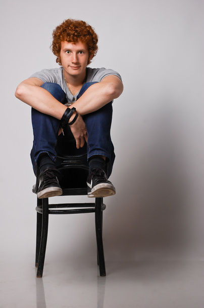 Божевільний імбир молодий чоловік на стільці
 - Фото, зображення