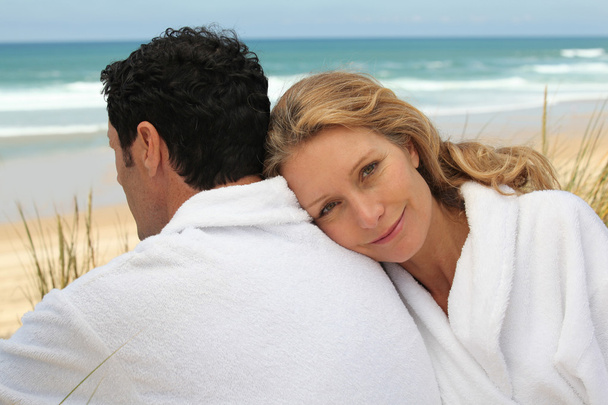 egy férfi és egy nő visel háziköntös, a strandon. - Fotó, kép