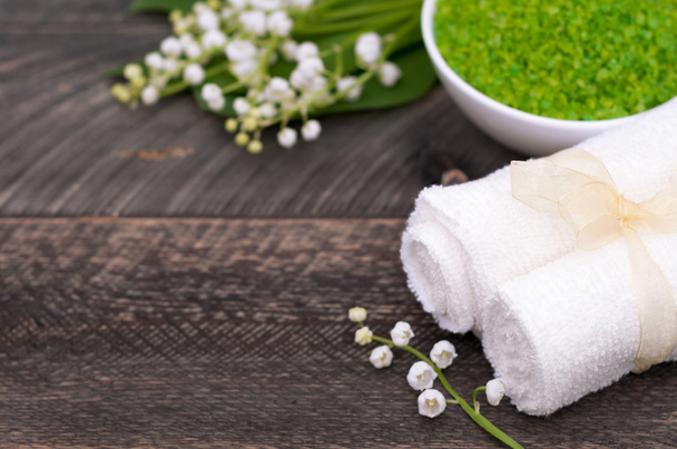 Natural green sea salt and towel for bath and spa on a wooden bo - Fotó, kép