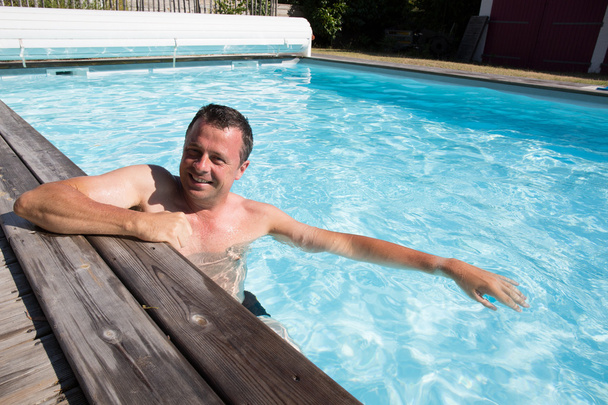 Heureux homme attrayant penché au bord de la piscine
 - Photo, image