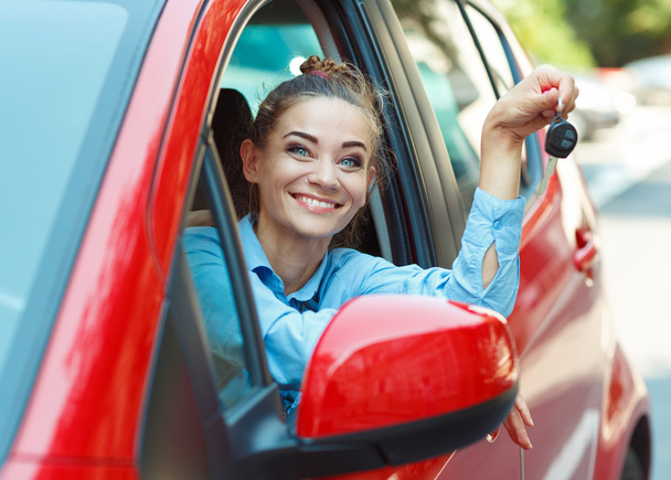 Young cheerful woman sitting in a car with keys in hand - Photo, Image