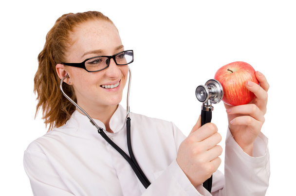 Bonita doctora con estetoscopio y manzana aislada en whit
 - Foto, imagen