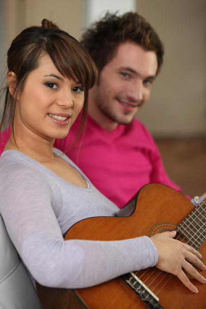 Woman playing the guitar for her boyfriend - Фото, изображение