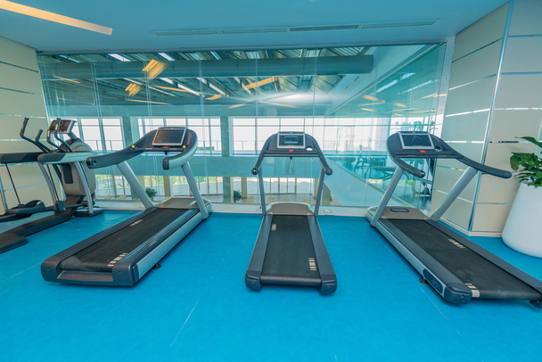 Moderne fitnessruimte met diverse sportuitrusting - Foto, afbeelding