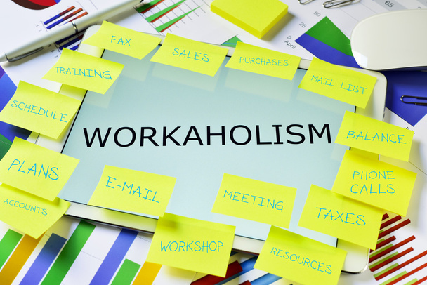 el texto workaholism en una tableta en un escritorio de la oficina
 - Foto, Imagen