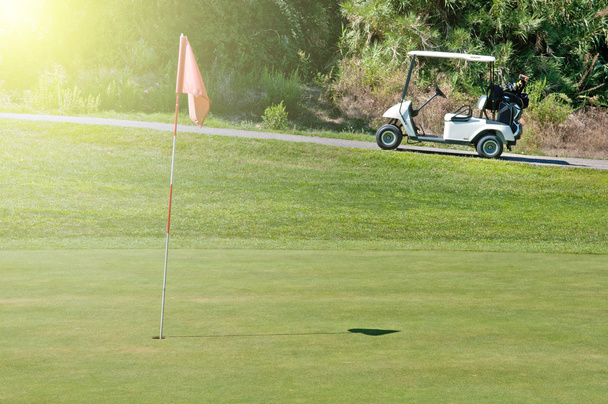 Golfwagen neben einem Loch - Foto, Bild