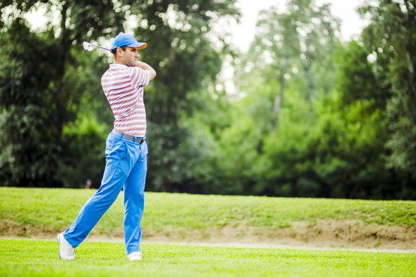 Golfaaja harjoittelee ja keskittyy ennen laukausta ja sen jälkeen
 - Valokuva, kuva