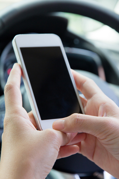 Молодая женщина держит мобильное устройство в машине
 - Фото, изображение