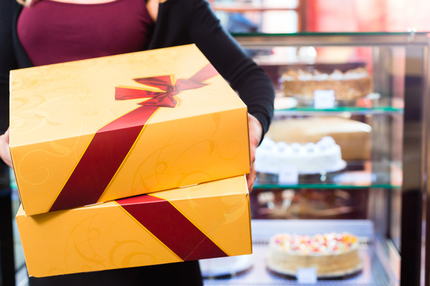Woman presenting takeaway boxes of confectionery - Photo, Image
