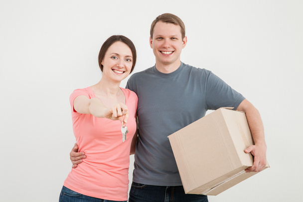 Чоловік і жінка тримають коробку і ключі
 - Фото, зображення