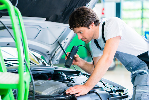 Mechanic with diagnostic tool in car workshop - Photo, Image