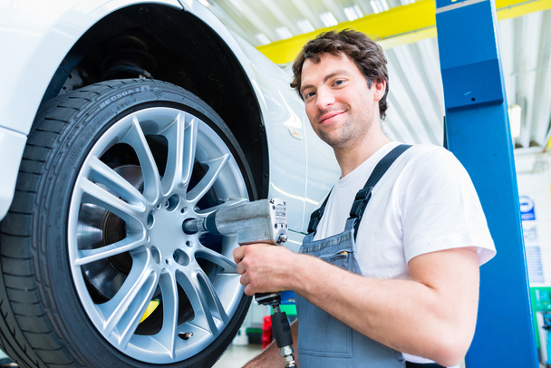 Mechanic tire change in car workshop - 写真・画像