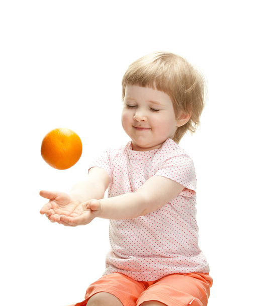 Girl playing with orange - Foto, afbeelding