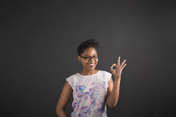 African woman with perfect hand signal on blackboard background - Fotografie, Obrázek