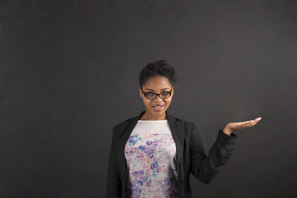Afrikanerin hält Hand auf Tafel-Hintergrund - Foto, Bild