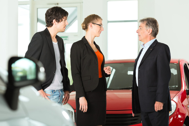 hombre con pareja y autos en concesionario de automóviles
 - Foto, imagen