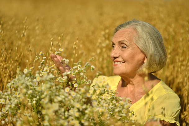 Senior woman with flowers - Foto, Bild
