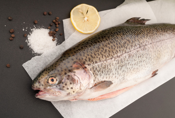Whole trout fish with lemon, salt and black pepper - Photo, Image