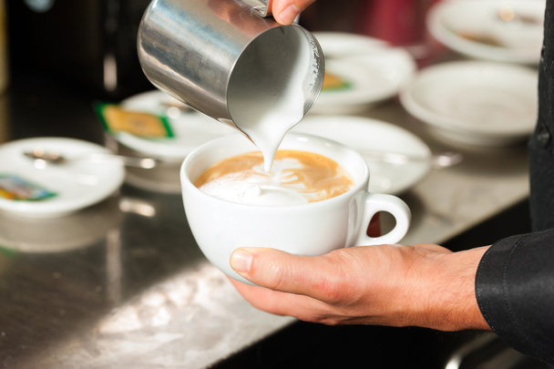 Barista making cappuccino in his coffeeshop - Foto, imagen