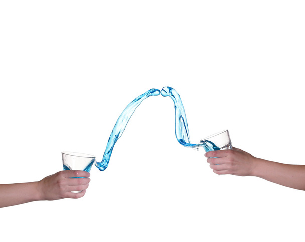 Blue water splashing in glass held by hand, white background - Fotografie, Obrázek