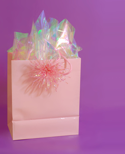 Рожевий подарунковий мішок на фіолетовому фоні
 - Фото, зображення