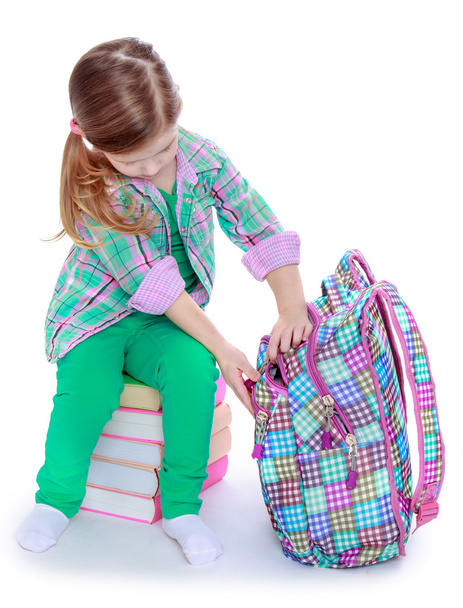 schoolgirl examines a backpack - 写真・画像