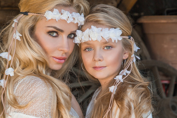 Красивая блондинка с маленькой девочкой, обнимающейся на Диком Западе в белых костюмах
 - Фото, изображение