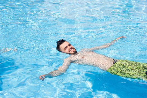 man swimming in the pool. blue water, summer, positive - Fotoğraf, Görsel