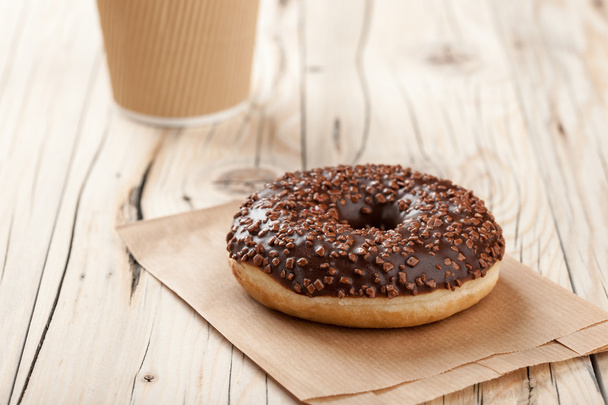 Donut and paper cup on wooden table - Foto, Imagen