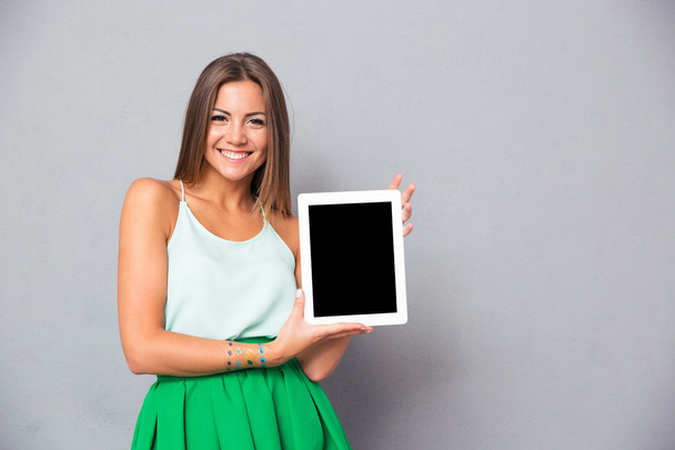 Smiling woman showing blank tablet computer screen - Fotó, kép