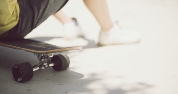 Άνθρωπος συνεδρίασης χαλαρώνοντας σε ένα skateboard - Πλάνα, βίντεο