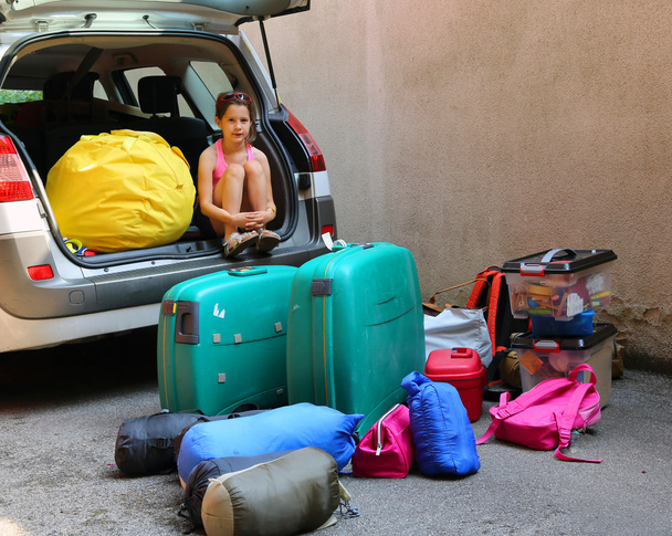 menina com corações vestido carrega o carro de bagagem
 - Foto, Imagem