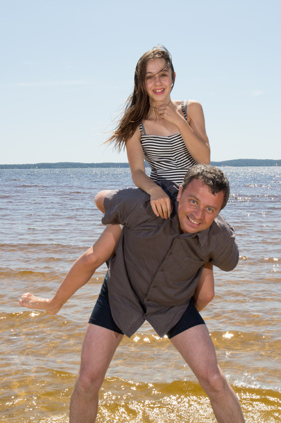 Отец подвозит дочь на спине
 - Фото, изображение