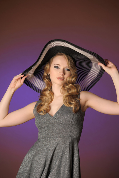 Fashion girl in a big hat in the studio - Photo, image