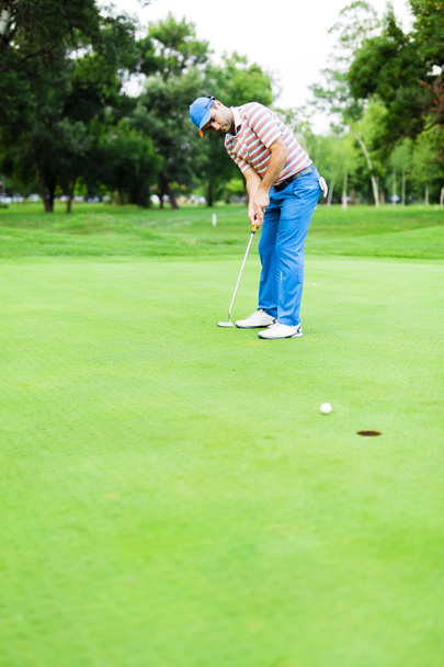 Golfista toma el tiro verde de poner
 - Foto, Imagen
