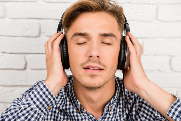 stylish man listening to music on headphones - Foto, Imagen