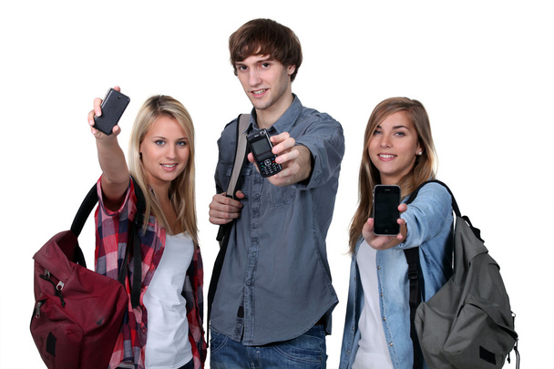 Three teenage students with backpacks and cellphones - Photo, Image
