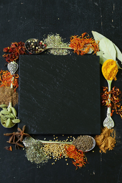 Różne przyprawy na czarnym tle (papryka kurkumy, pieprzu, anyż, cynamon, szafran) - Zdjęcie, obraz