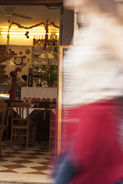 İtalyan restoran menü ile hızlı bir şekilde Passe yürüyen bulanık kadın - Fotoğraf, Görsel