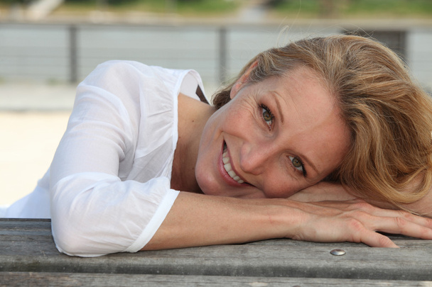 Close-up van een lachende vrouw zitten buiten - Foto, afbeelding