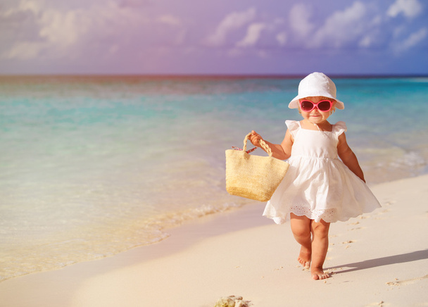 мила маленька дівчинка гуляє на літньому тропічному пляжі
 - Фото, зображення