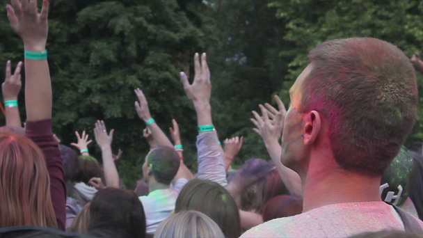 Юноши и девушки наслаждаются традиционным фестивалем красок, прыгают с поднятыми руками
 - Кадры, видео