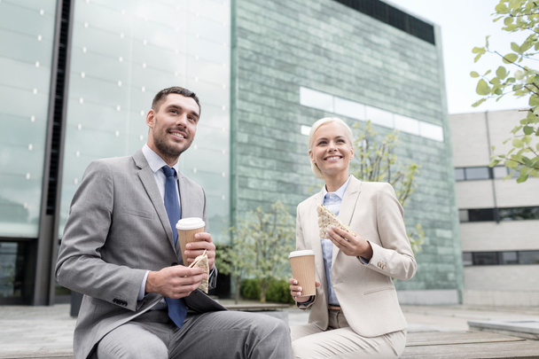 smiling businessmen with paper cups outdoors - Фото, изображение