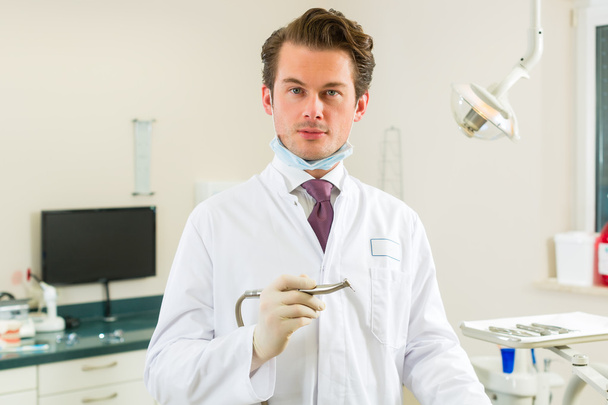 Οδοντίατρος στην χειρουργική του κατέχει ένα τρυπάνι - Φωτογραφία, εικόνα