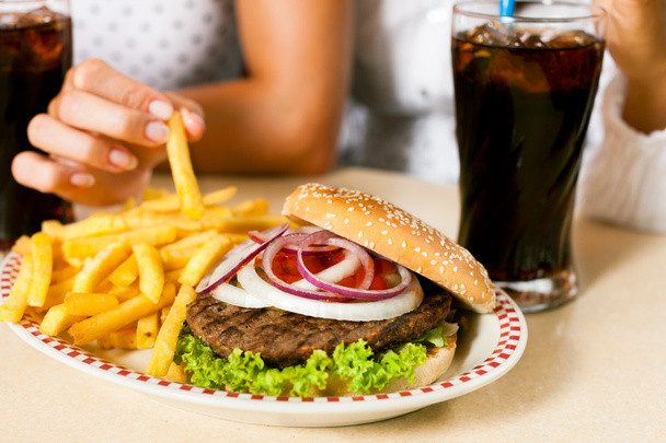 vrouwen eten hamburger en frisdrank drinken - Foto, afbeelding
